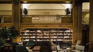 Une bibliothèque avec des étagères, des sièges et un escalier.