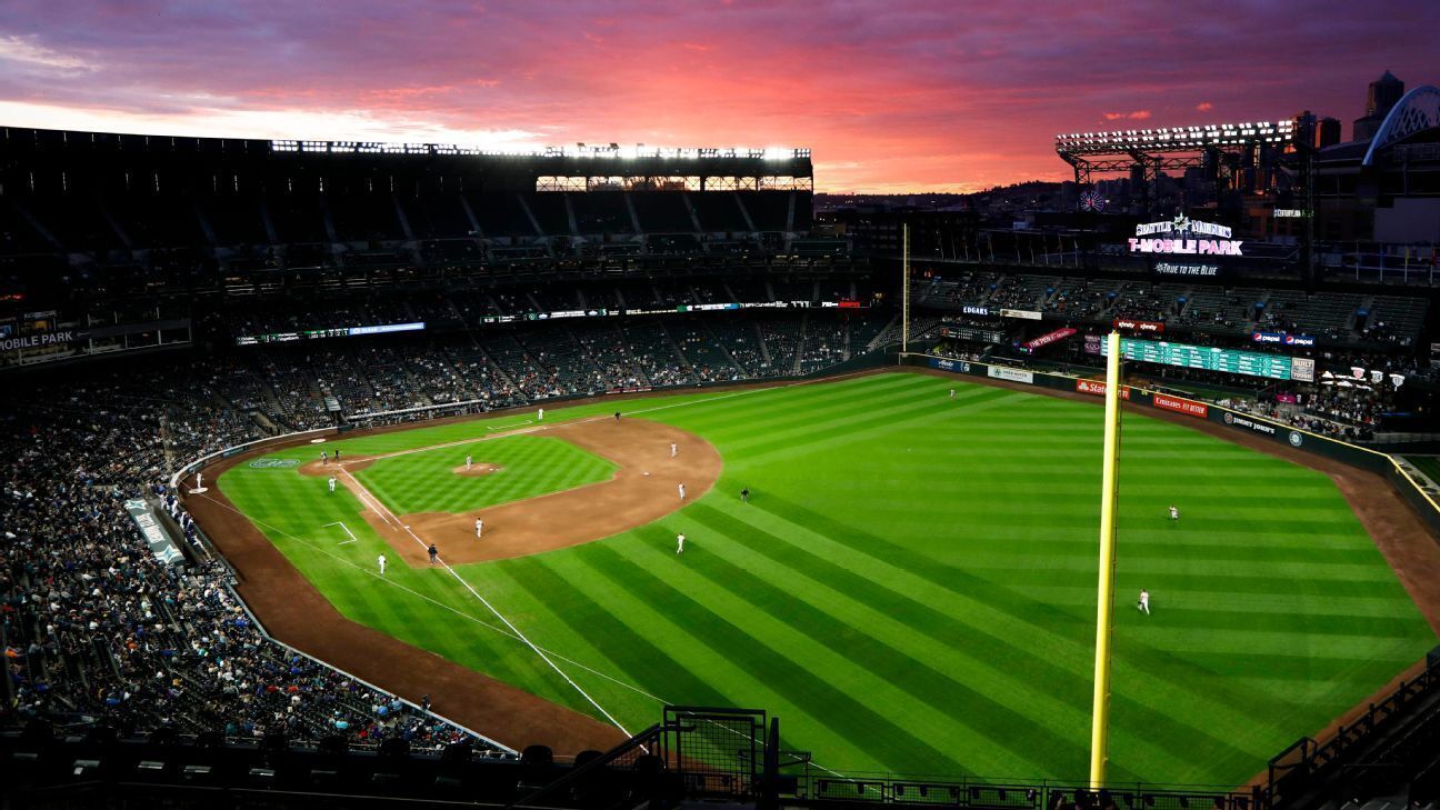 A baseball stadium with a large seating capacity, a central field, and a scoreboard.