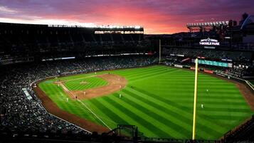 A baseball stadium with a large seating capacity, a central field, and a scoreboard.