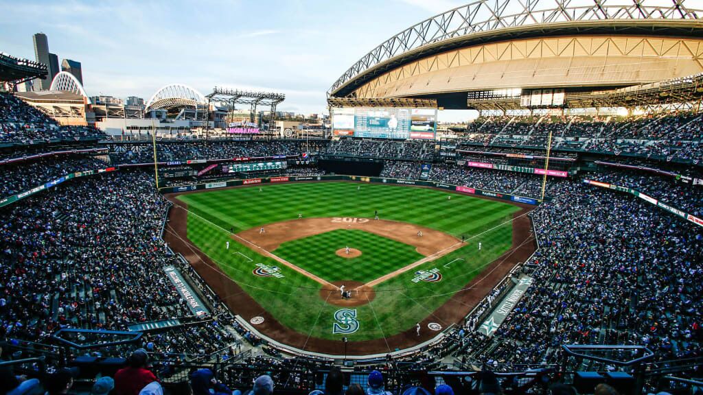 A large stadium with multiple seating levels, a central field, and a prominent scoreboard.