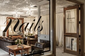 Experience refined luxury in this elegantly designed space with a grand chandelier, plush sofa, and leather armchair.
