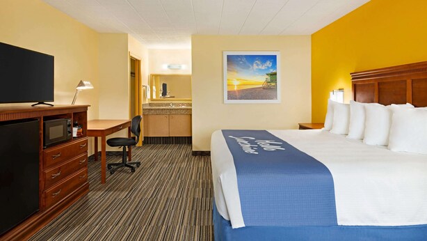 Une chambre d’hôtel équipée d’un lit, d’un bureau, d’une chaise et d’un téléviseur.