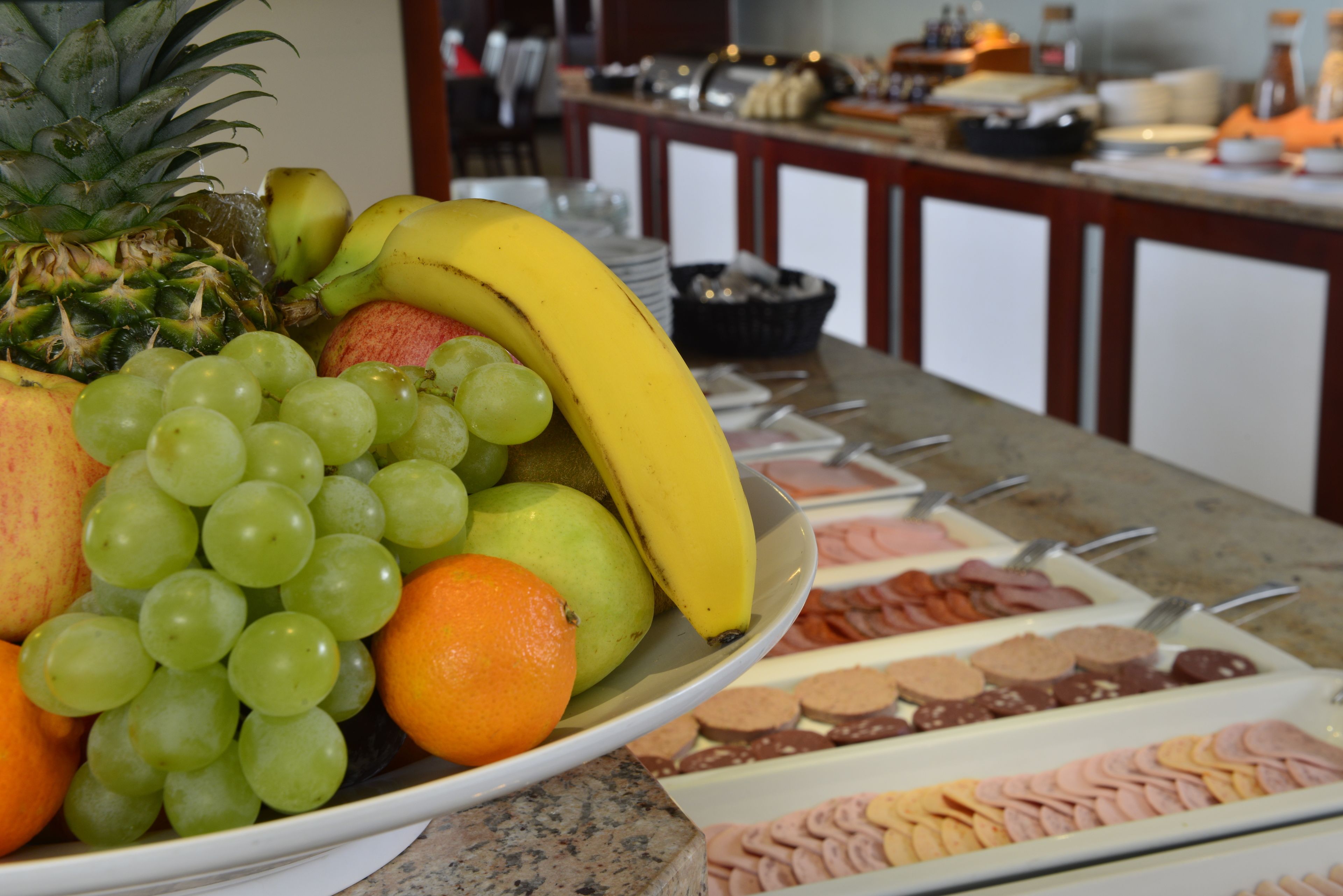 Un bufé con una variedad de frutas y pasteles.