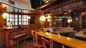 A bar area with a piano, wooden chairs, and a long counter. - Michel Hotel Wetzlar (Wetzlar)