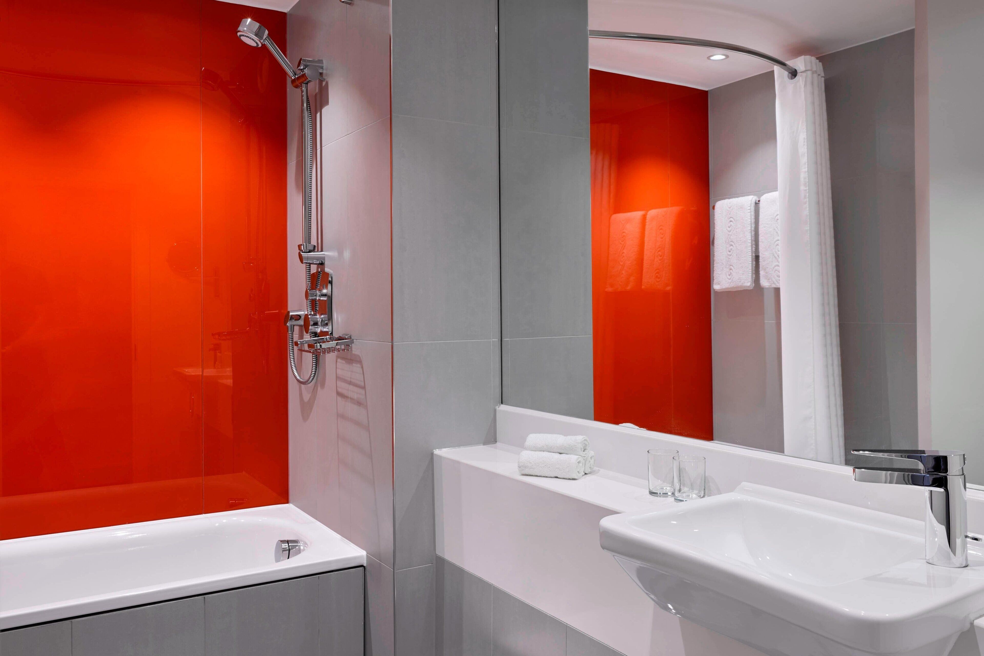 Une salle de bain moderne avec une baignoire blanche, un lavabo et une douche.