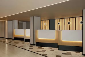 A reception area with modern design, featuring a reception desk, a waiting area, and a patterned floor.