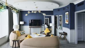 A modern living room with a round coffee table, beige sofas, and yellow throw pillows.
