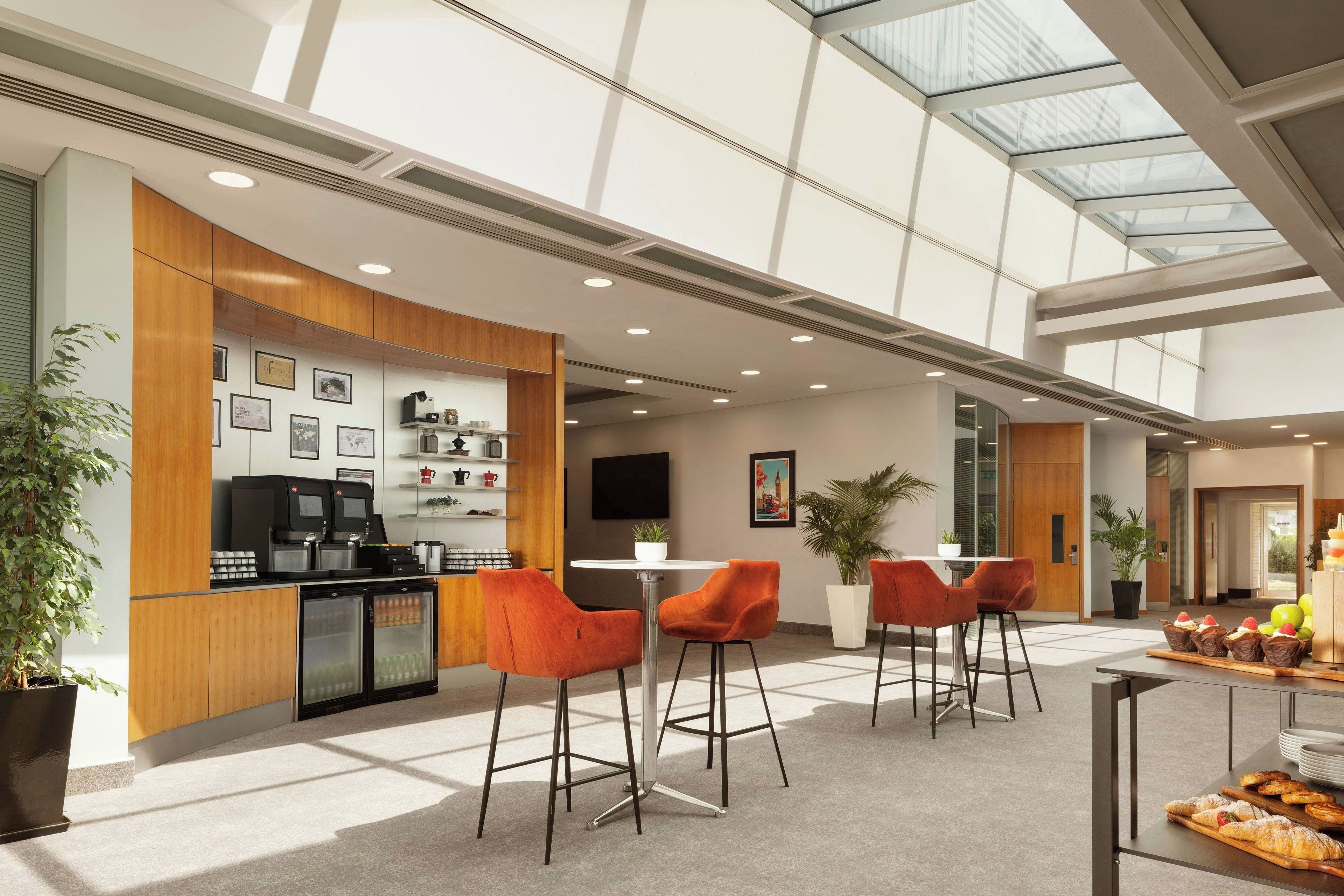 A modern interior with a kitchen area, seating, and a glass ceiling.