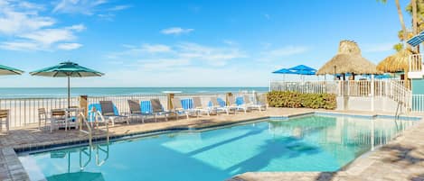 Alberca al aire libre, sombrillas en la alberca y camastros