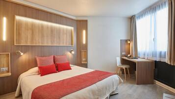 Une chambre d’hôtel moderne avec un grand lit, un bureau et une chaise.