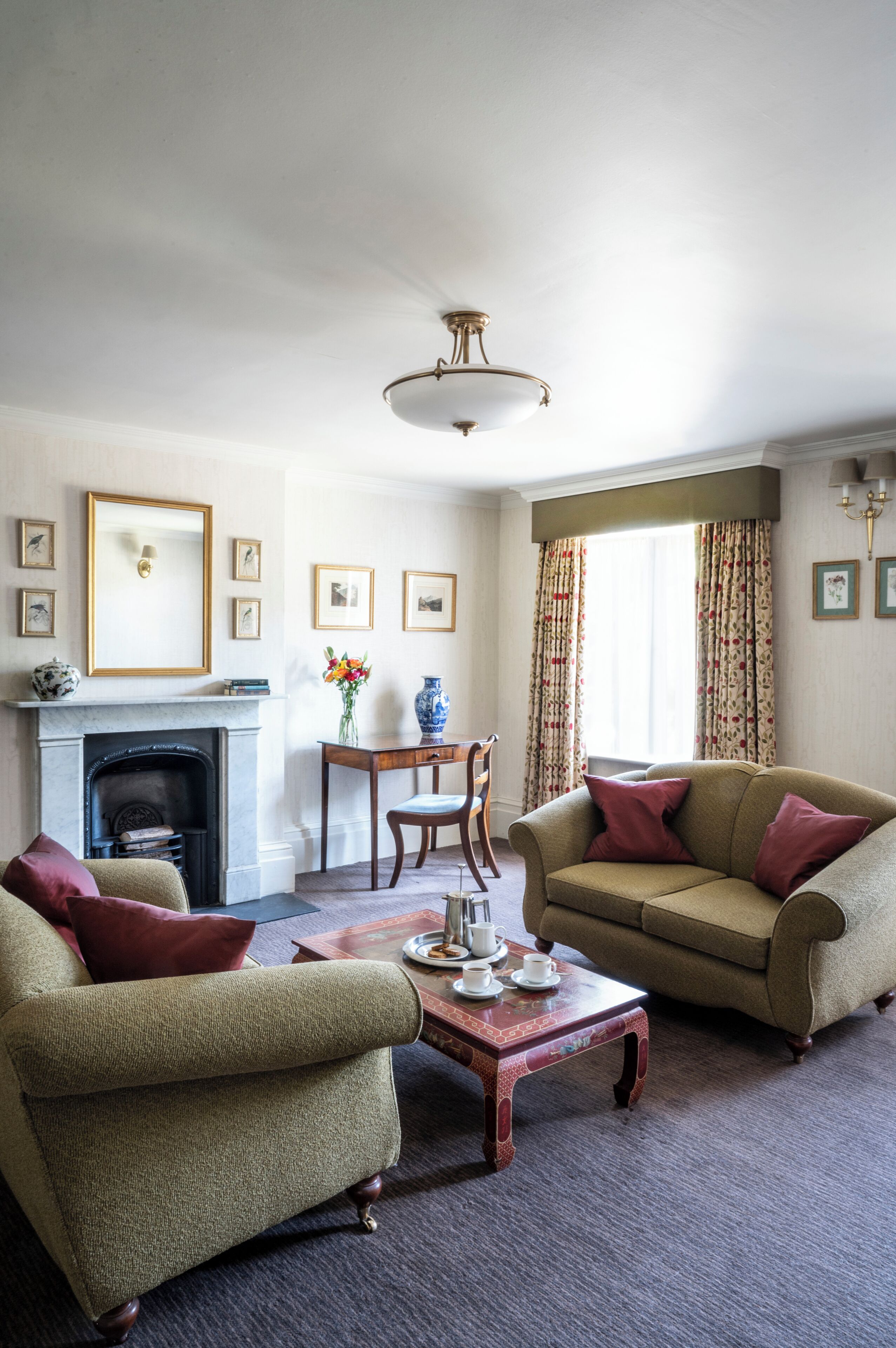 A living room with a fireplace, a sofa, a coffee table, and a dining table with chairs.