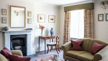 A living room with a fireplace, a sofa, a coffee table, and a dining table with chairs.