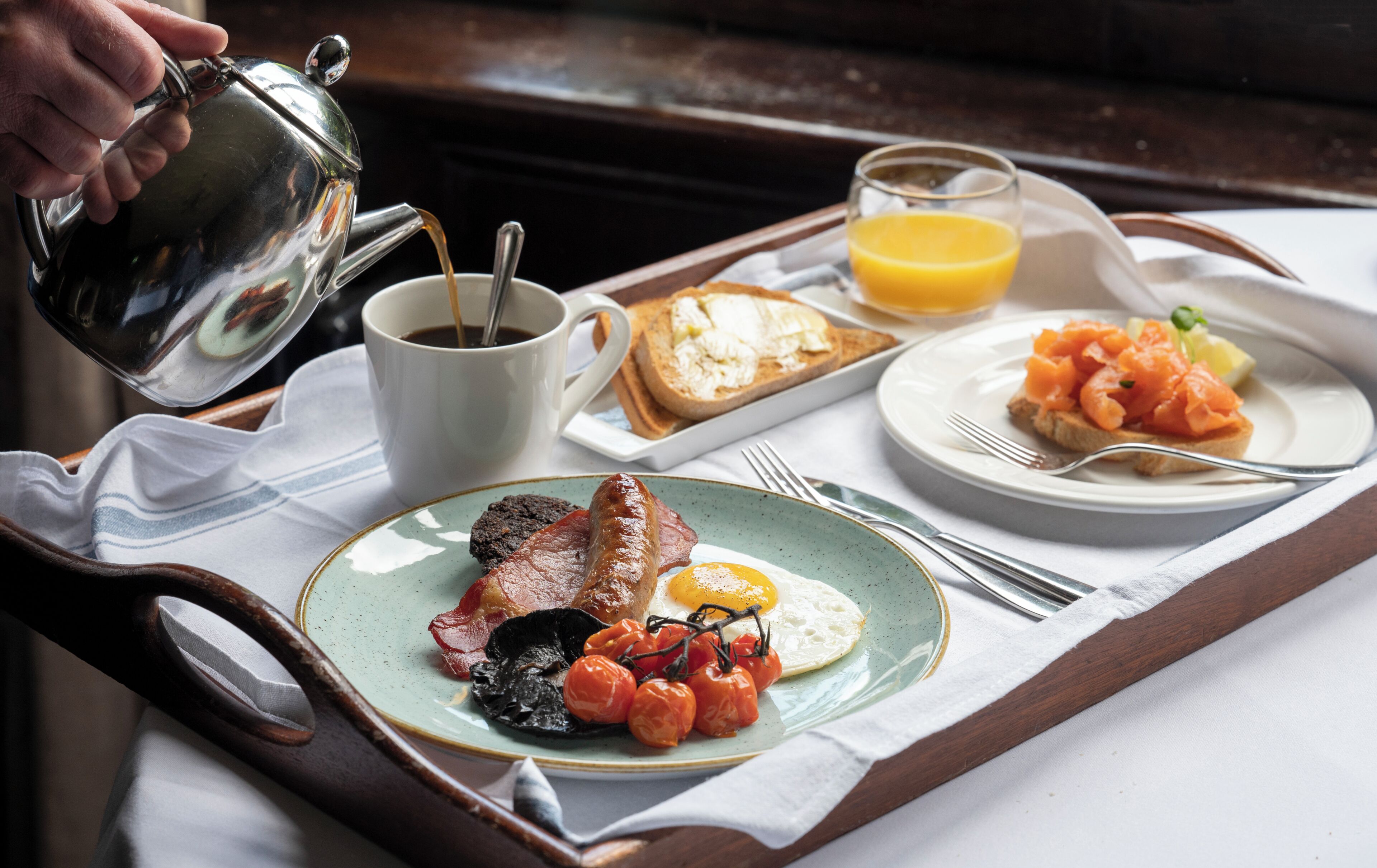 Un plateau de petit-déjeuner avec des toasts, du saumon, des tomates et un œuf au plat.