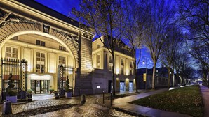 Un bâtiment historique doté d’une entrée imposante, d’un chemin pavé et d’une pelouse bien entretenue.