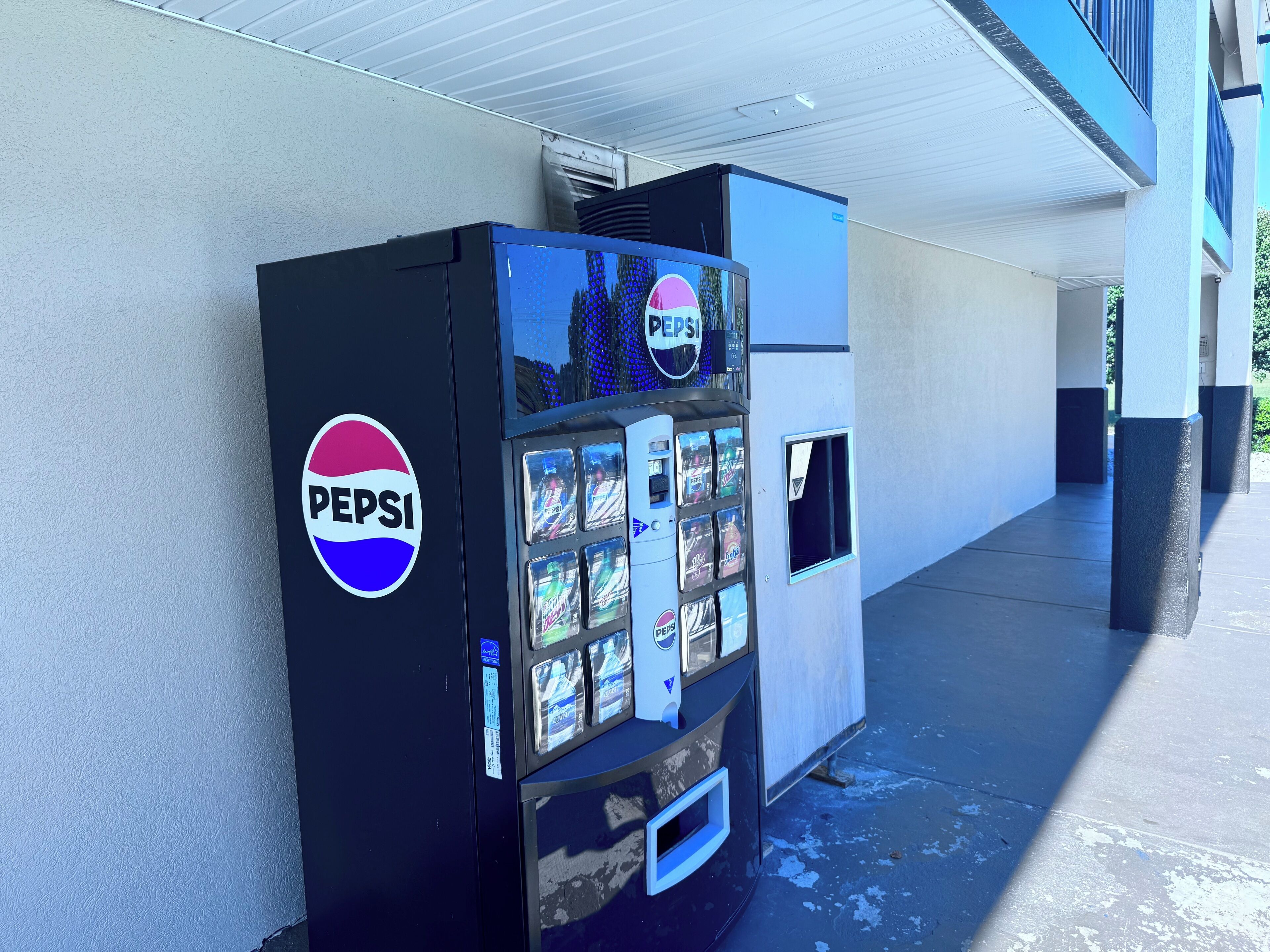 Una macchina automatica nera per Pepsi con diverse bevande e un grande logo Pepsi.