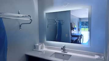 Un baño moderno con un espejo grande, un lavabo y un perchero para toallas.