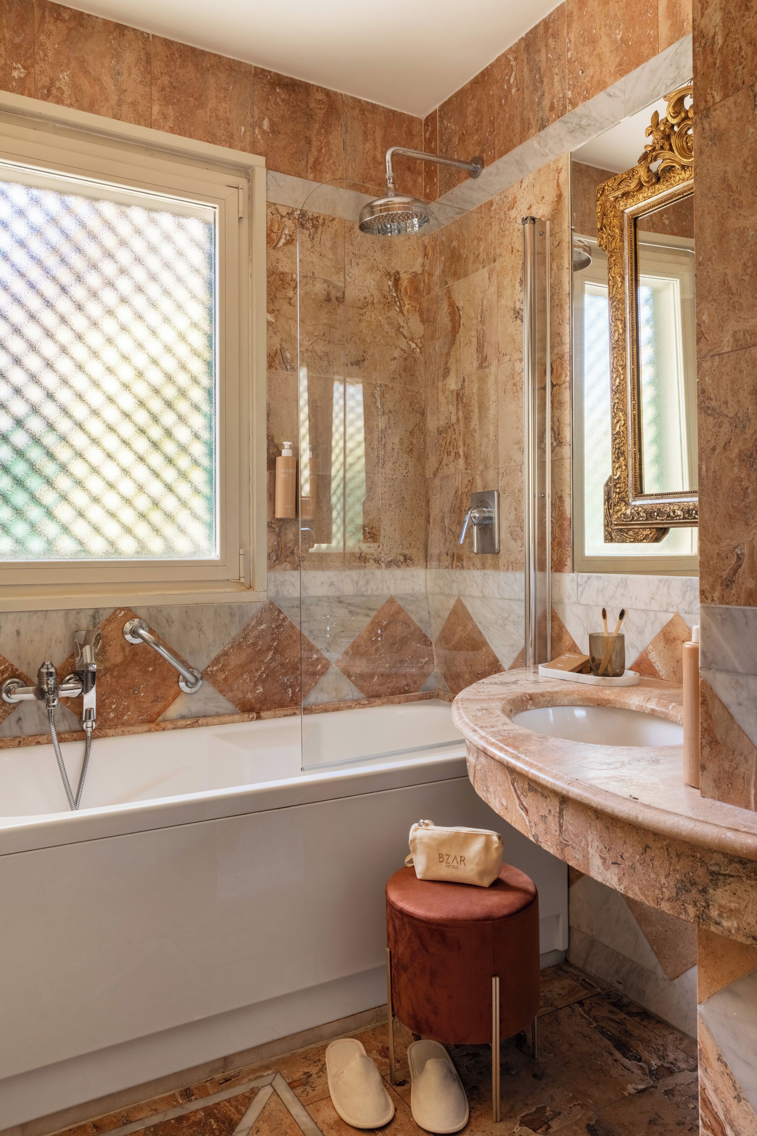 A bathroom with a bathtub, a shower, a vanity with a sink, a mirror, and a window.