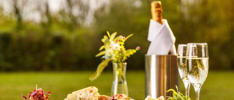 A table with various dishes, a bottle of champagne, and two glasses of wine.