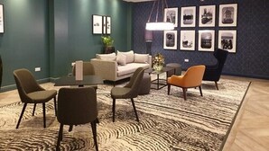 A modern living room with a sofa, chairs, a coffee table, and a patterned rug. - Mercure Cardiff (Cardiff)
