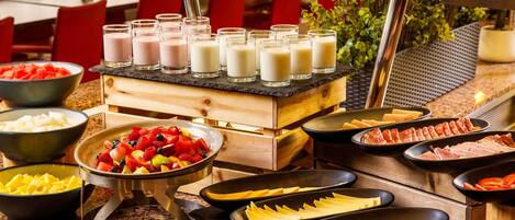 A buffet with various food items including fruits, cheeses, and meats.