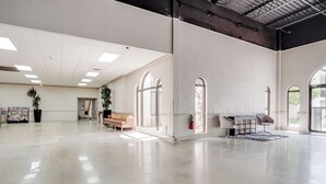 A spacious, well-lit room with a high ceiling, large windows, and a clean, polished floor. - Cottonwood Suites Savannah Hotel & Conference Center (Pooler)