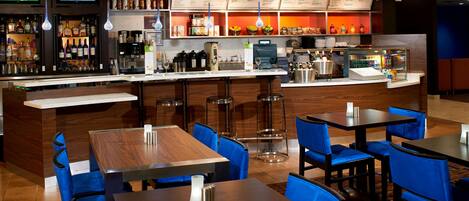 A restaurant with a bar area, multiple tables and chairs, and a menu board above the bar.