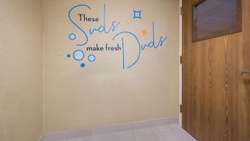A wall with a decorative phrase and a wooden door.
