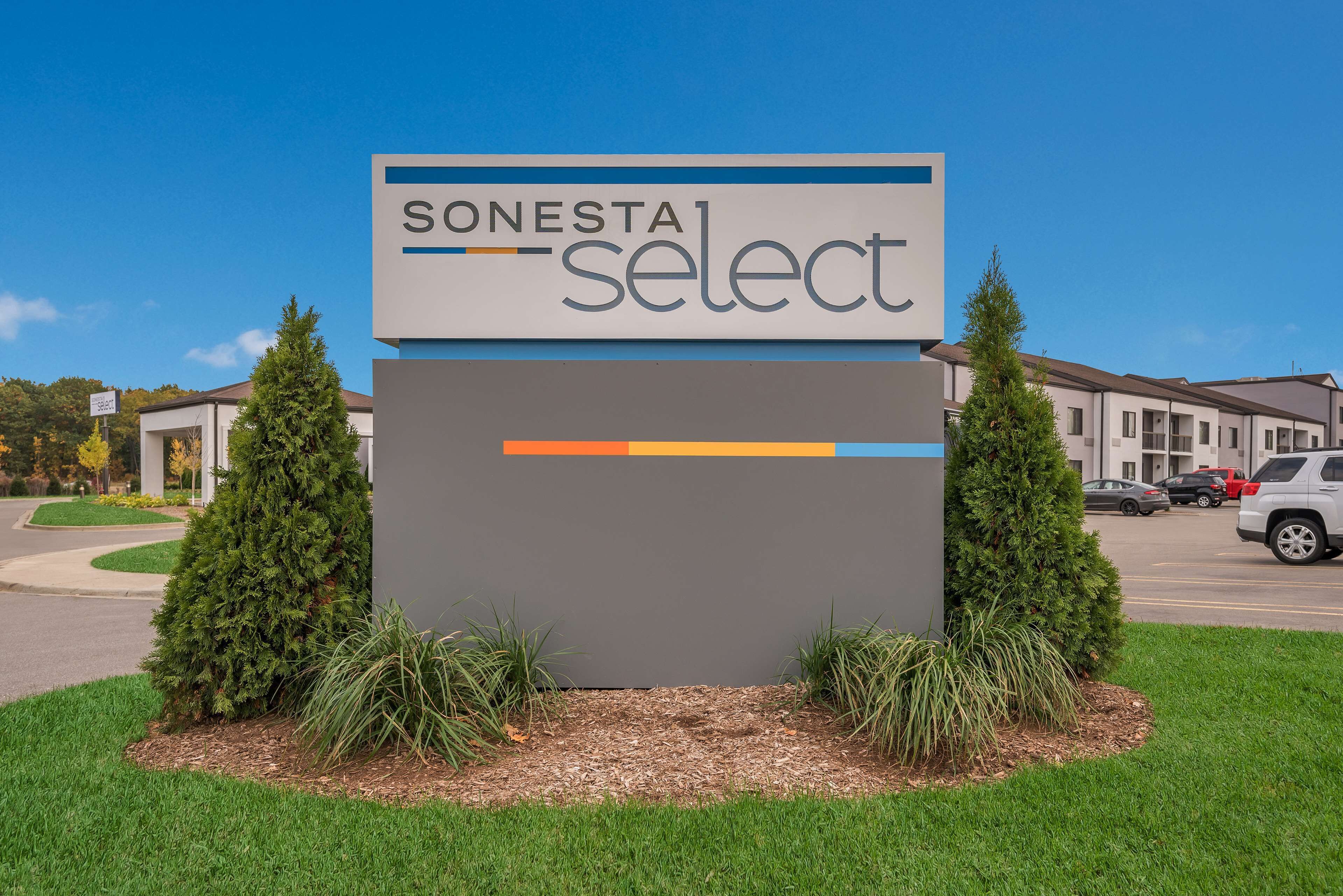 Naamplaatje voor hotel Sonesta Select, met een helder zicht op het groen en parkeerplaatsen.