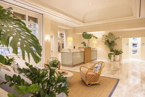 A spacious lobby with a reception desk, seating area, and potted plants. - Four Seasons Resort Palm Beach (Palm Beach)