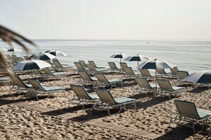 On the beach, white sand, sun loungers, beach umbrellas