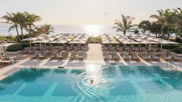 A poolside area with lounge chairs and umbrellas, a clear view of the ocean, and a pool. - Four Seasons Resort Palm Beach (Palm Beach)