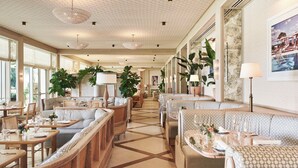 A spacious hotel lobby with a central seating area, large windows, and a tiled floor. - Four Seasons Resort Palm Beach (Palm Beach)