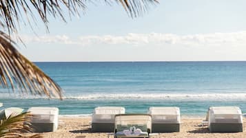 En la playa, playa de arena blanca, camastros y sombrillas