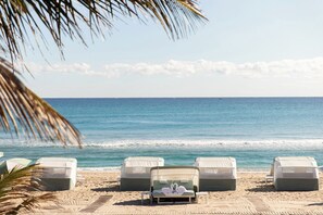 On the beach, white sand, sun-loungers, beach umbrellas