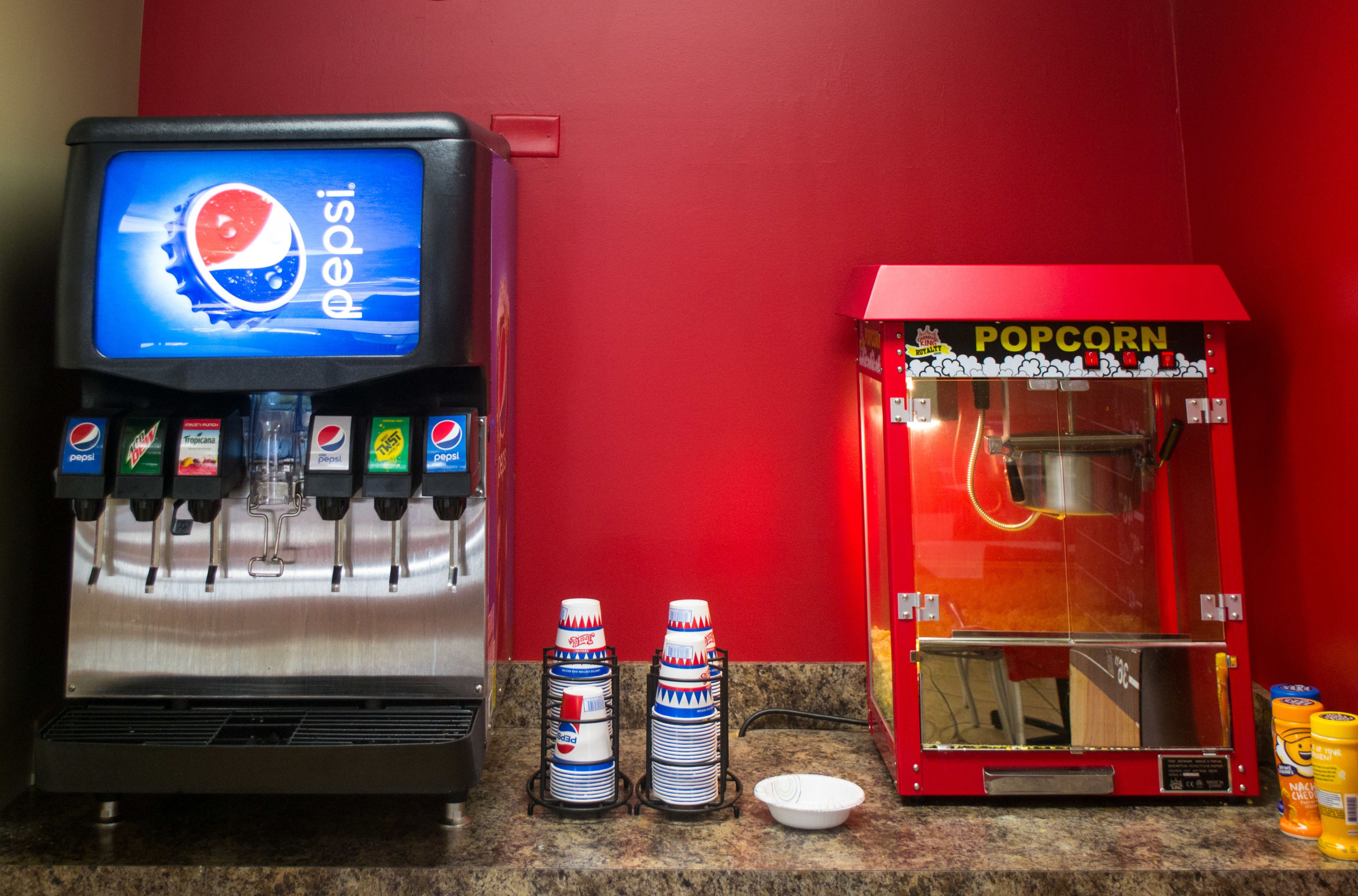 Ein Getränkeautomat mit Pepsi und anderen Erfrischungsgetränken sowie eine Popcornmaschine.