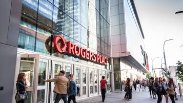 A modern building with a large glass facade and a prominent sign reading "Rogers Place".
