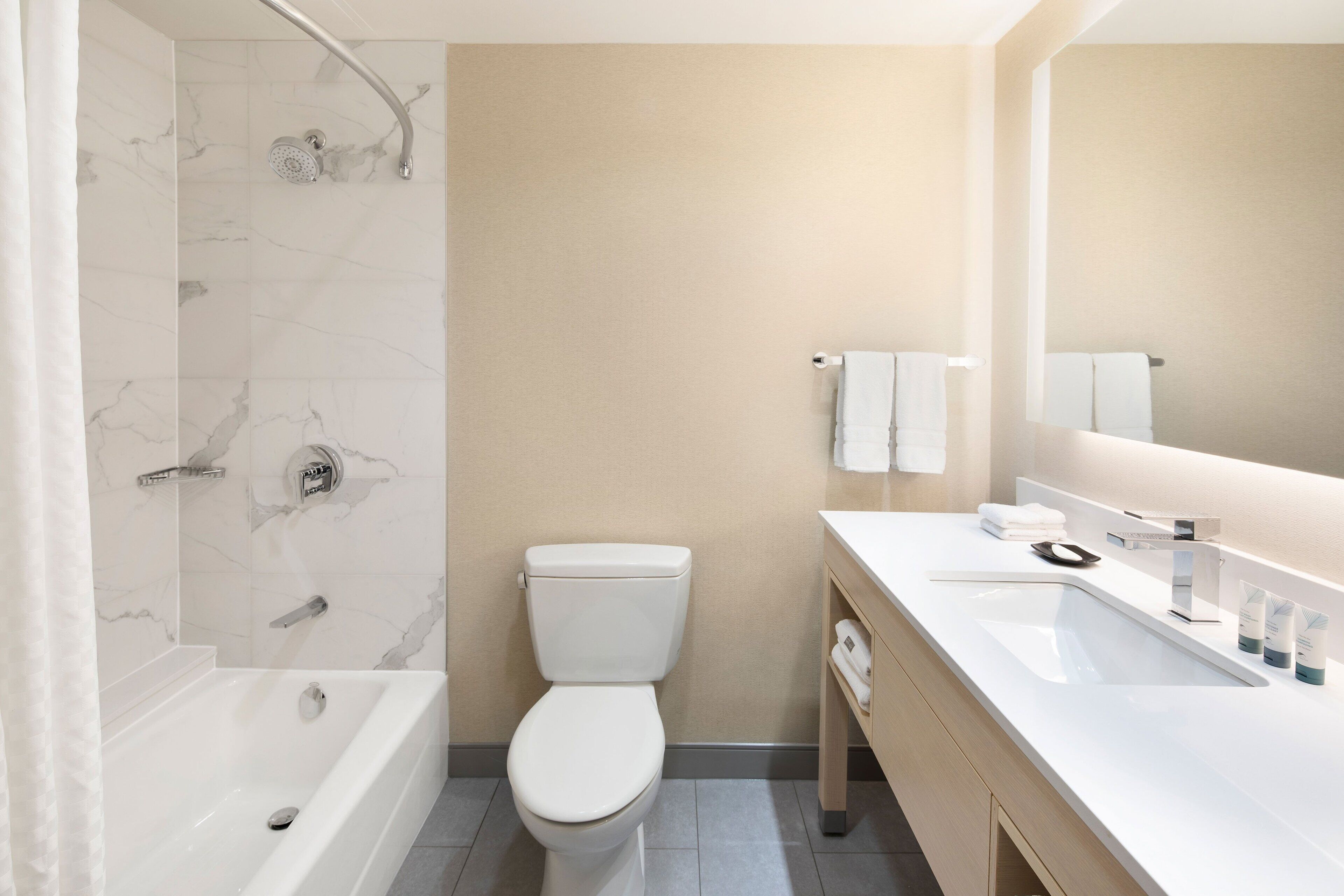 combined shower/bathtub, designer toiletries, hair dryer, towels