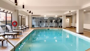 An indoor swimming pool with lounge chairs and a life preserver. - The Westin Edmonton (Edmonton)