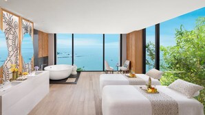A modern hotel room with a large window, a bathtub, two beds, and a sitting area. - Taj Cidade de Goa Heritage, Goa (Panaji)