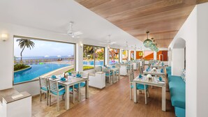 A restaurant with a pool view, wooden ceiling, and blue and white decor. - Taj Cidade de Goa Heritage, Goa (Panaji)