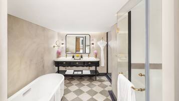 A modern bathroom with a double sink vanity, a bathtub, and a glass shower enclosure.
