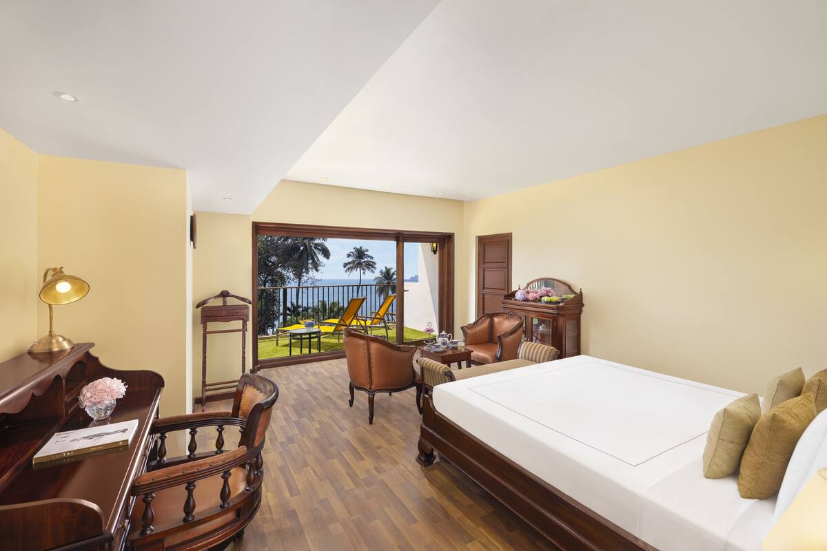 Une chambre d’hôtel équipée d’un lit, d’un bureau, d’une chaise et offrant une vue sur l’extérieur.