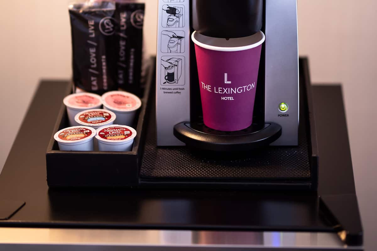 Una máquina de café Keurig con un portavasos morado y una caja de cápsulas de café.