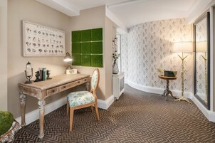 Un estudio con un escritorio de madera, una pared con estampado verde y una alfombra estampada.