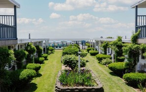 Ein Innenhof mit Pool, umgeben von gepflegten Hecken und freiem Blick auf den Ozean.