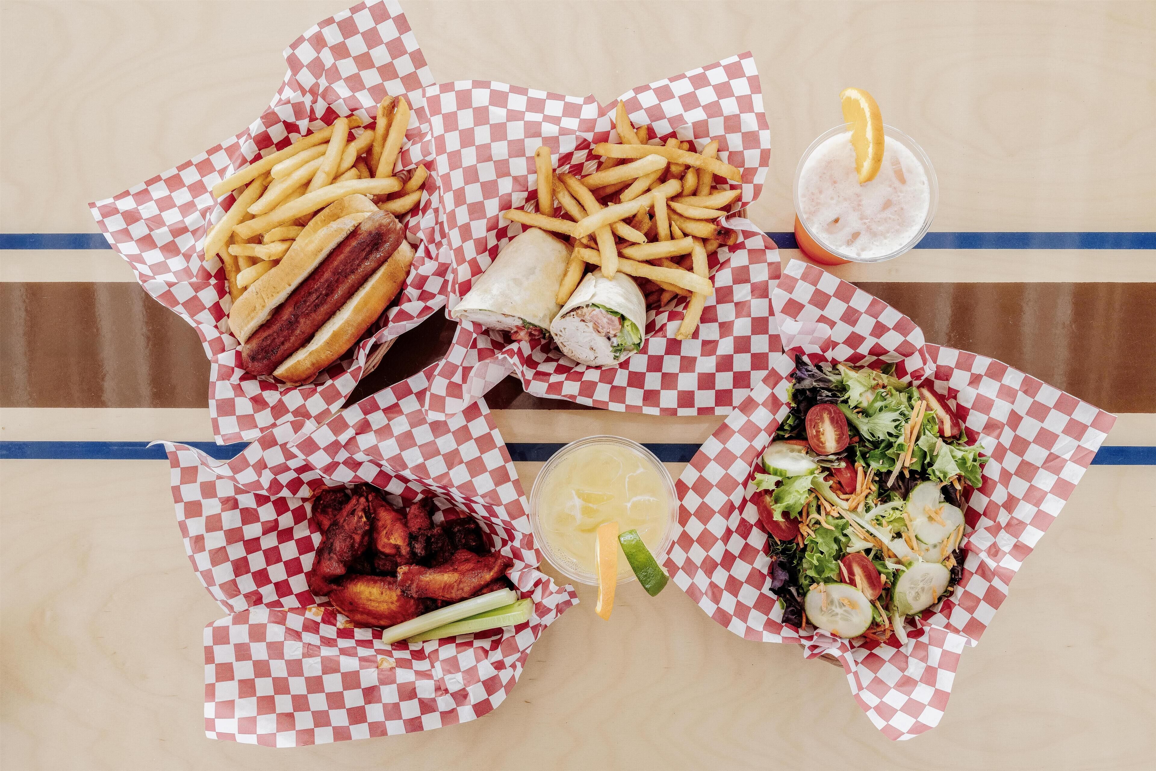 A table with various food items including a sandwich, fries, a salad, and a drink.
