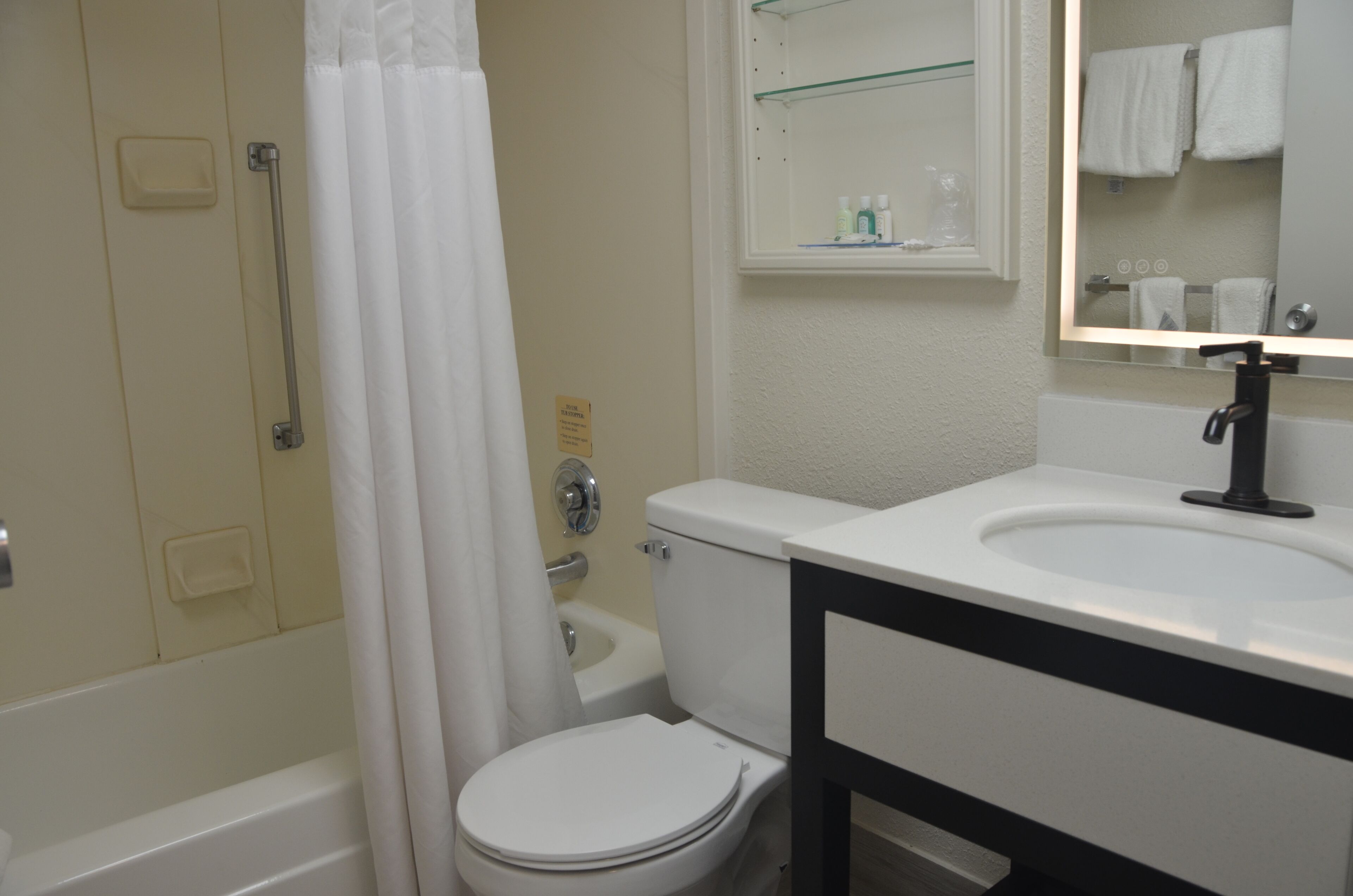 A bathroom with a toilet, sink, and shower.