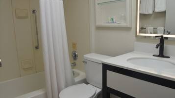 A bathroom with a toilet, sink, and shower.
