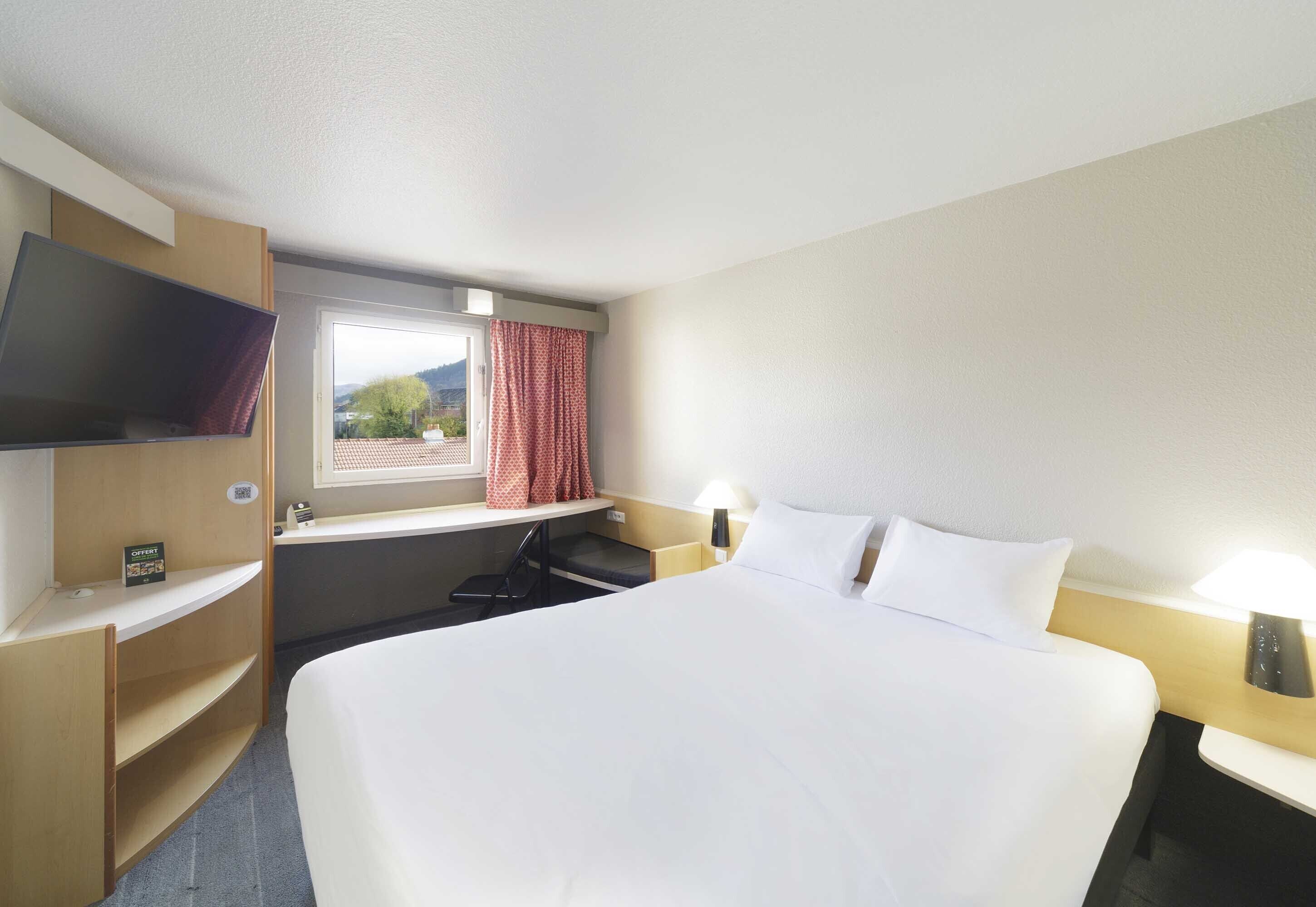 Premium bedding, desk, laptop workspace, blackout drapes