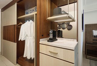 A modern bathroom with a wooden vanity, a towel rack, and a coffee machine.